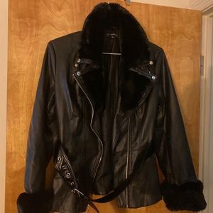 A black faux jacket with fur on the collar and fur on both sleeves